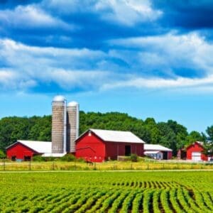 Red barn and silos on farm with lush green fields and blue sky in Spokane, WA — Boyd Insurance serving Spokane County with trusted insurance solutions.