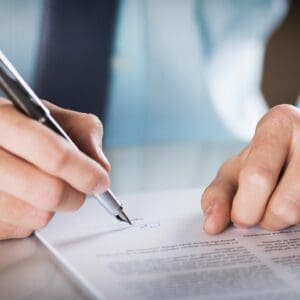 Flexible insurance policy signing with a pen on paper, representing personalized coverage options.
