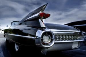 Vintage black Cadillac with chrome details in a parking lot, showcasing classic American luxury cars in Spokane WA.