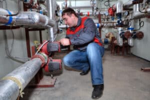 Repairing industrial plumbing in Spokane, WA, on commercial boiler pipes, focusing on plumbing services, industrial maintenance, and safety inspections at Boyd Insurance.