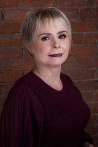 Wines, alcohol, and spirits on a textured wooden bar counter with a leather armchair and decorative items, cozy bar interior, warm lighting, intimate atmosphere, ideal for socializing or enjoying a drink.